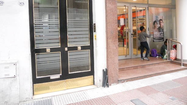 Un edificio con una puerta negra y un letrero con el número 1424.