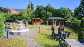 A patio area with a fountain, seating, and a gazebo. - Hotel Opal (Laatzen)