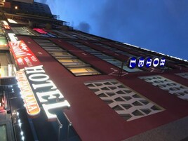 Un hotel con un letrero llamativo que dice "HOTEL" y una entrada visible.