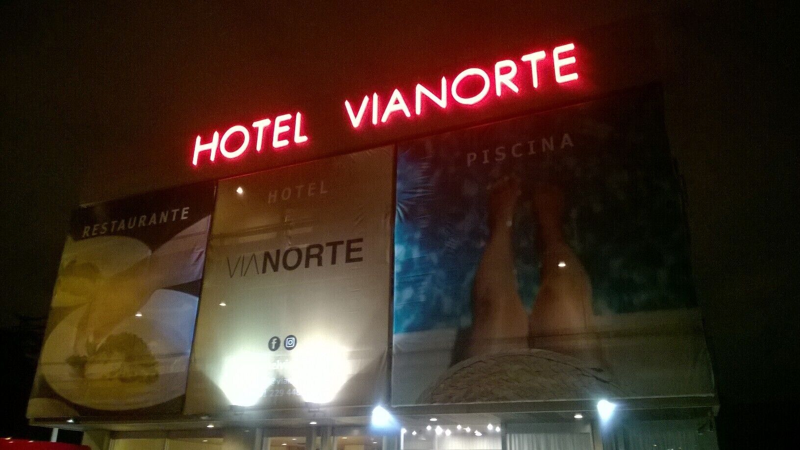 Une enseigne d’hôtel portant le nom « Vianorte » et une banderole faisant la publicité d’un restaurant.