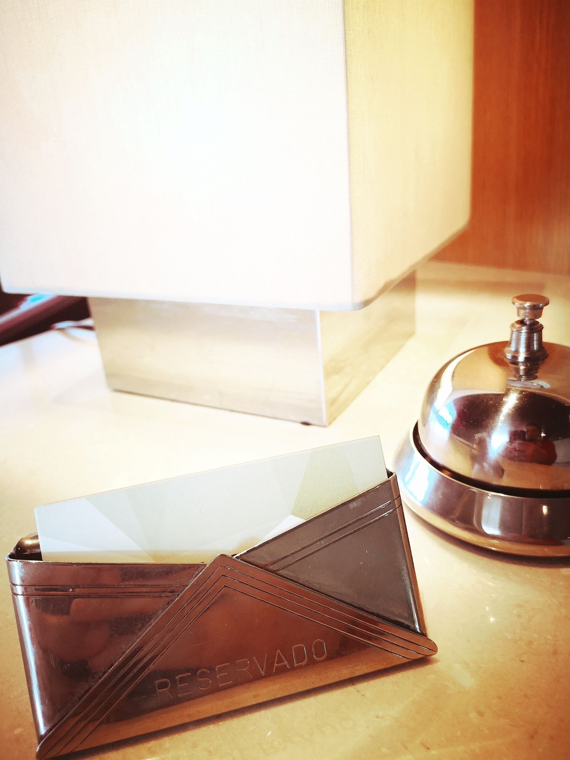 Habitación de hotel con escritorio, lámpara, minibar y bandeja para minibar.