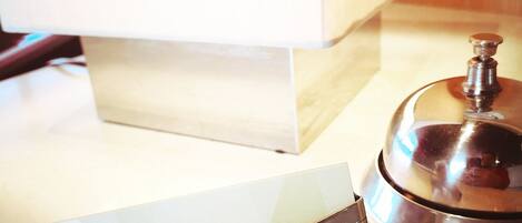 Une chambre d’hôtel équipée d’un bureau, d’une lampe, d’un minibar et d’un plateau de service pour le minibar.