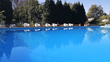Relax by the serene pool surrounded by lush greenery.