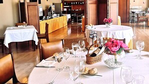 Ein Restaurant mit runden Tischen, gedeckt für ein Essen, mit weißen Tischdecken, Weingläsern und Brot.