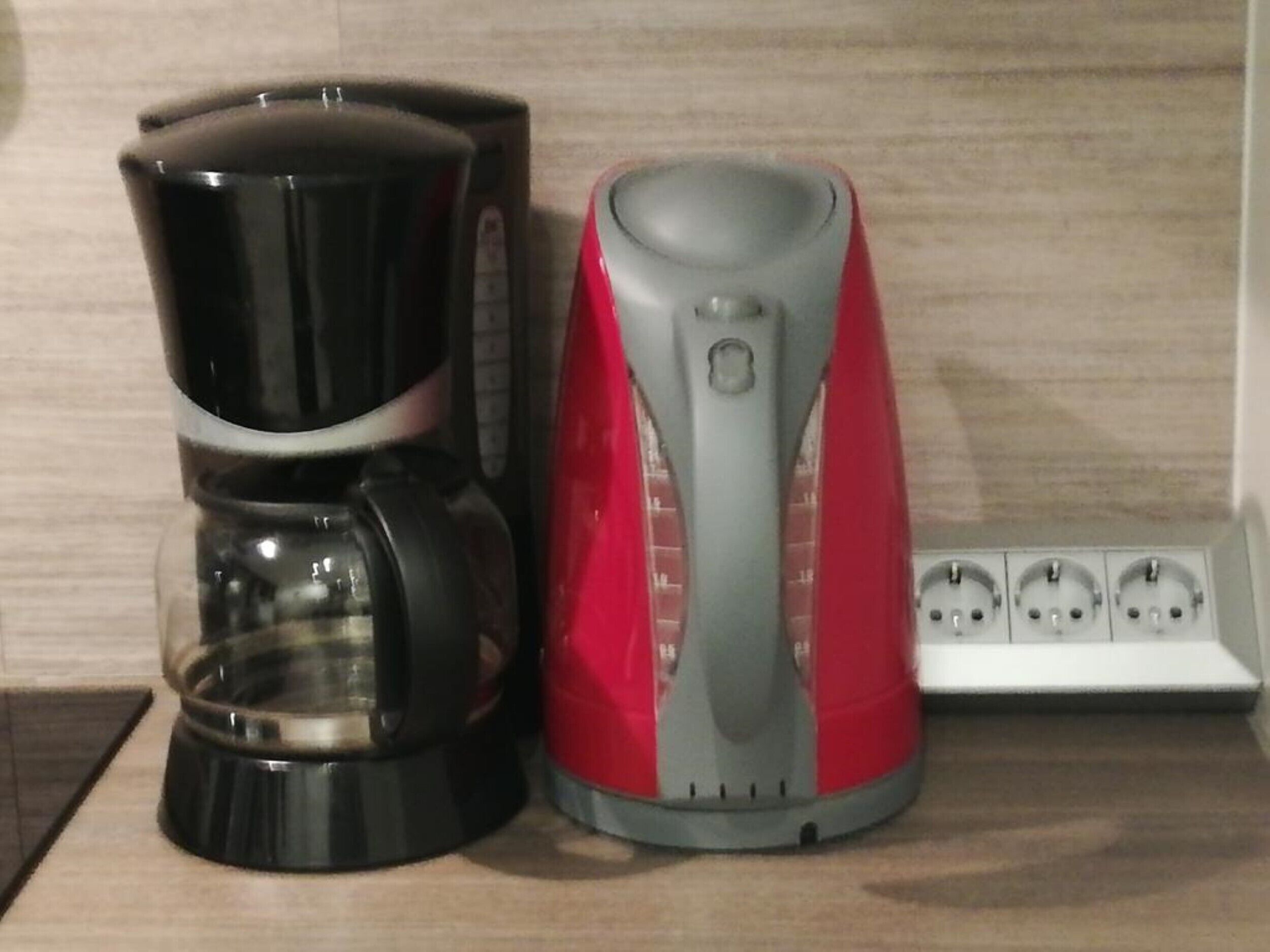 A coffee maker and a kettle on a countertop.