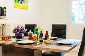 A dining table with plates, cutlery, and bottles of beverages.