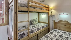 A bunk bed room with a mirror and bedside lamps.