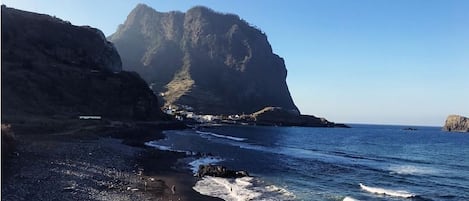 On the beach, black sand, 2 beach bars, surfing