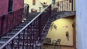 Una escalera con barandillas de metal ornamentadas que lleva a un balcón.