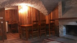 Une pièce rustique avec des murs en bois, une cheminée et un canapé blanc.