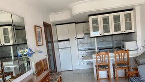 A compact living space with a kitchenette, a dining area, and a seating area.