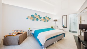 Un dormitorio moderno con una cama, una mesita de noche, una planta pequeña y una obra de arte en la pared.