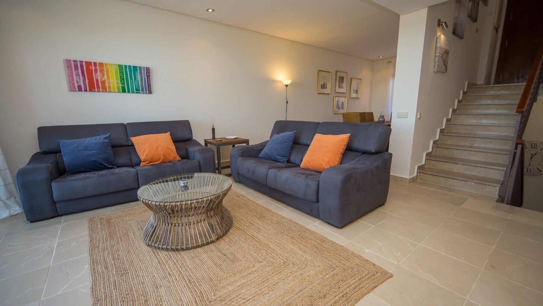 A living room with two sofas, a coffee table, and a staircase.