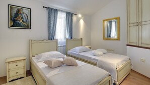 Ein Schlafzimmer mit zwei Betten, einem Nachttisch, einem Spiegel und einem Bild an der Wand.
