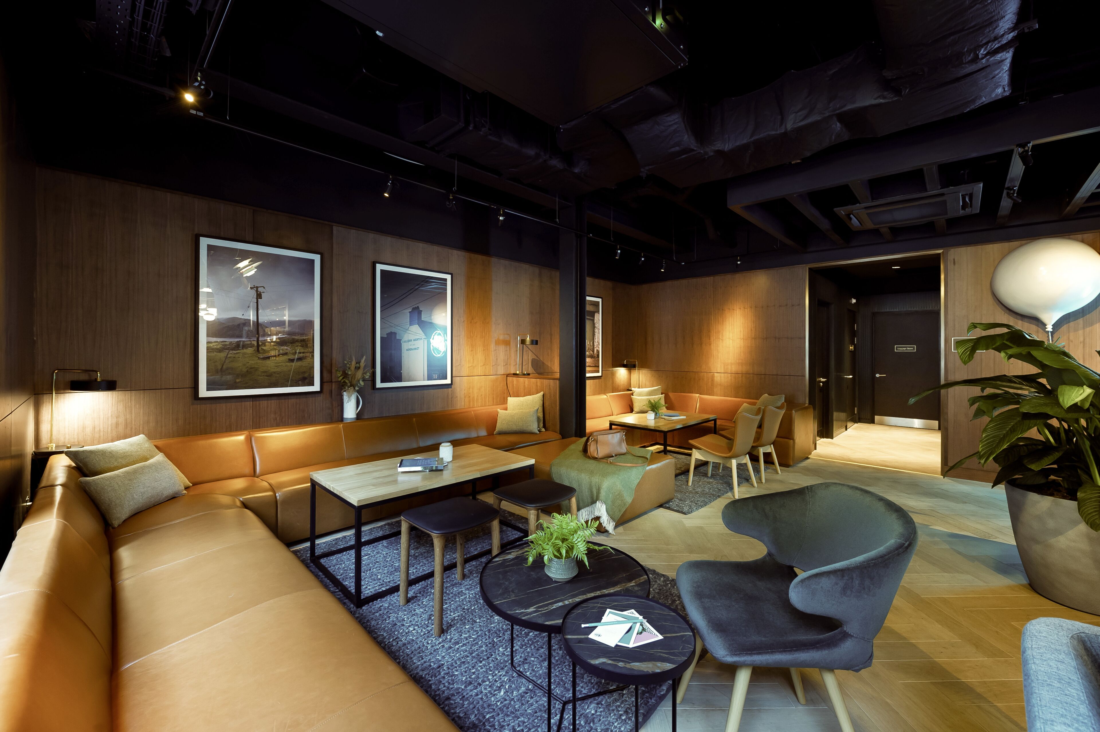 Un espace de détente moderne avec des canapés en cuir, une table basse et une plante en pot.