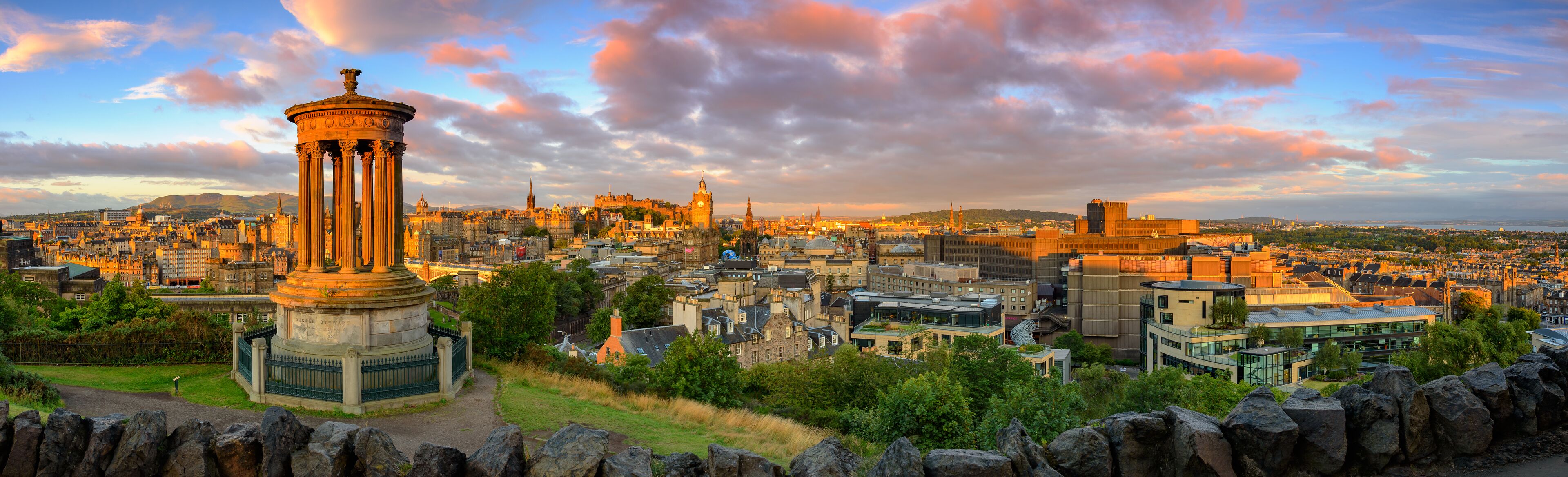 A cityscape with historic architecture, including a prominent columned monument and a clock tower.