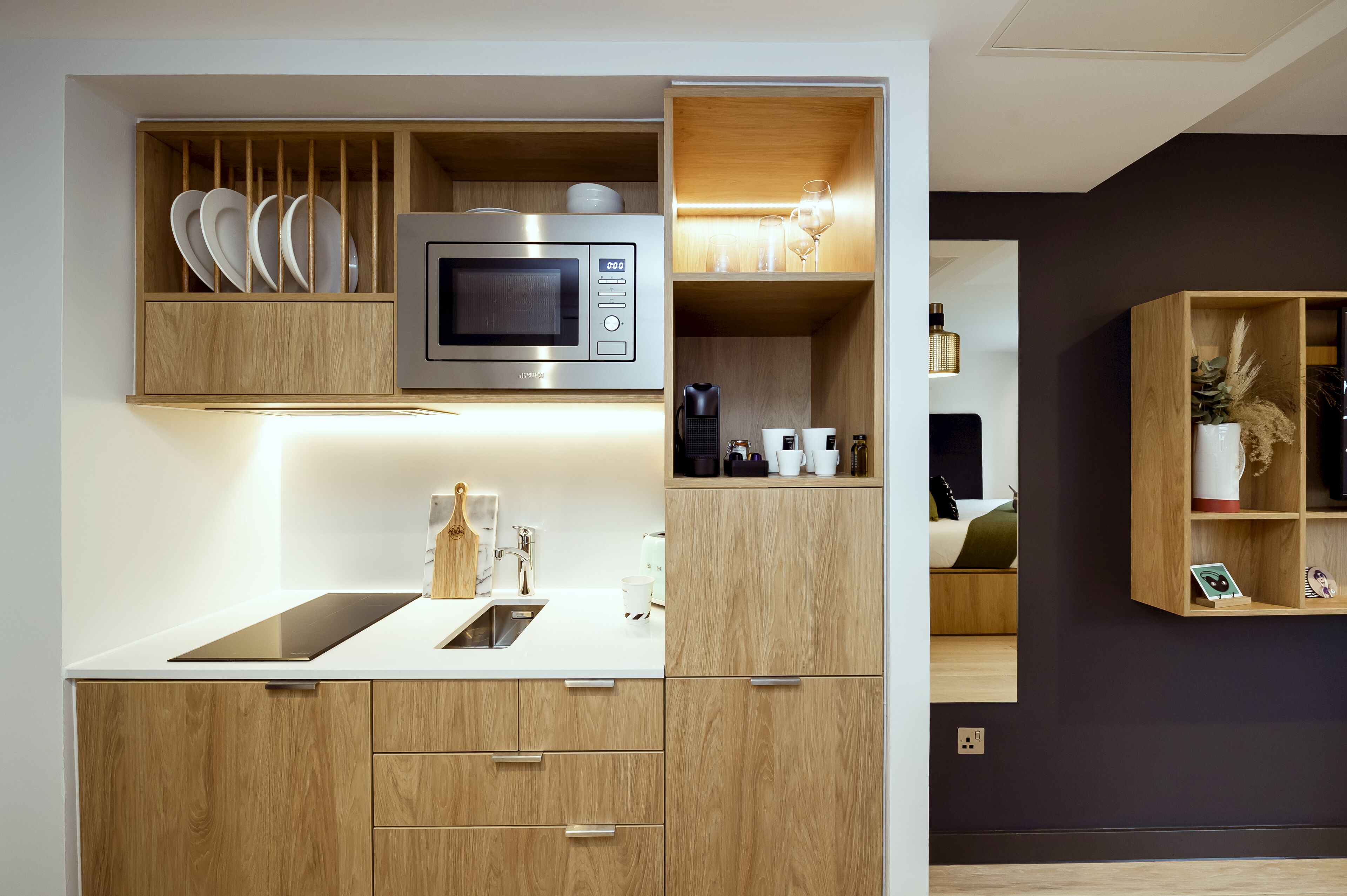 A modern kitchen with wooden cabinets, a built-in microwave, and a countertop with a sink.