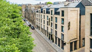 Una hilera de edificios modernos que combinan arquitectura tradicional y contemporánea, con diversos estilos de ventanas y materiales de construcción.