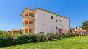 Un edificio residenziale a più piani con balconi e un prato curato.