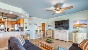 A spacious living room with a sofa, coffee table, and a TV area. - FFR205 - Beach Therapy by First Flight Rentals (Kill Devil Hills, NC 27948)