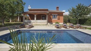 A house with a swimming pool, lounge chairs, and a garden. - Sunny villa 500 meters to beach with private pool (Peroj)