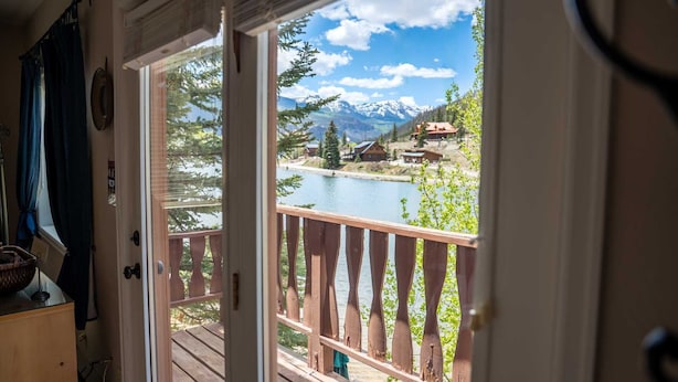 A wooden deck with a view of a lake and mountains.