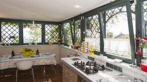 A kitchen with a dining area, large windows, and a view of the outdoors. - LUMIERE LIFE, cozy and bright living room in Castelnuovo Magra  (Castelnuovo Magra)