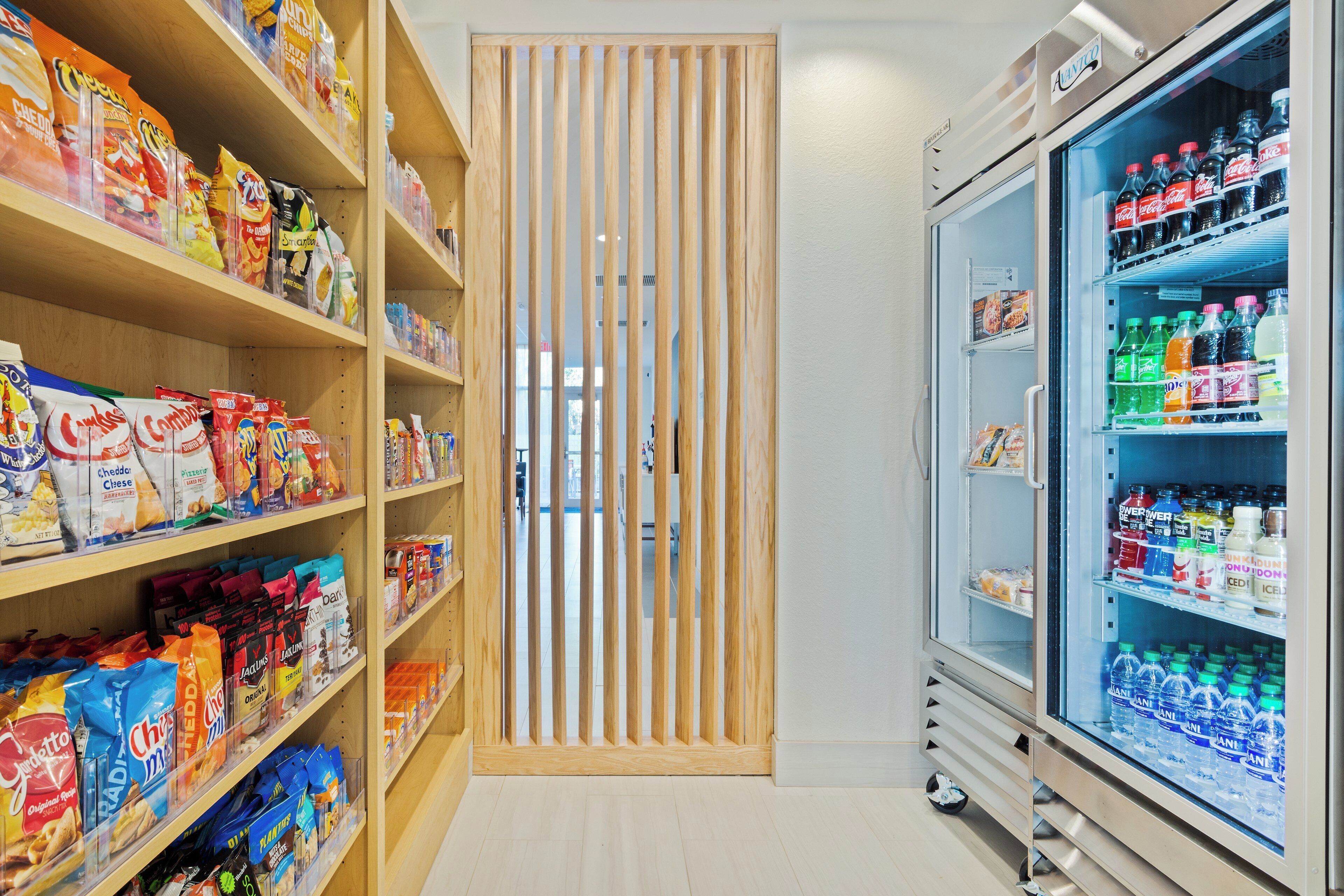 Un pasillo con alimentos empacados y una sección refrigerada con bebidas.