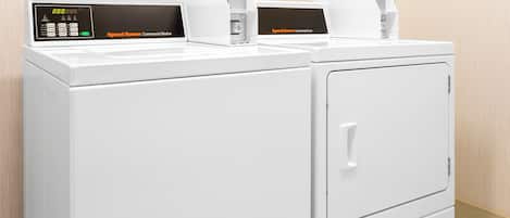 A pair of white commercial washers with digital displays and control panels.