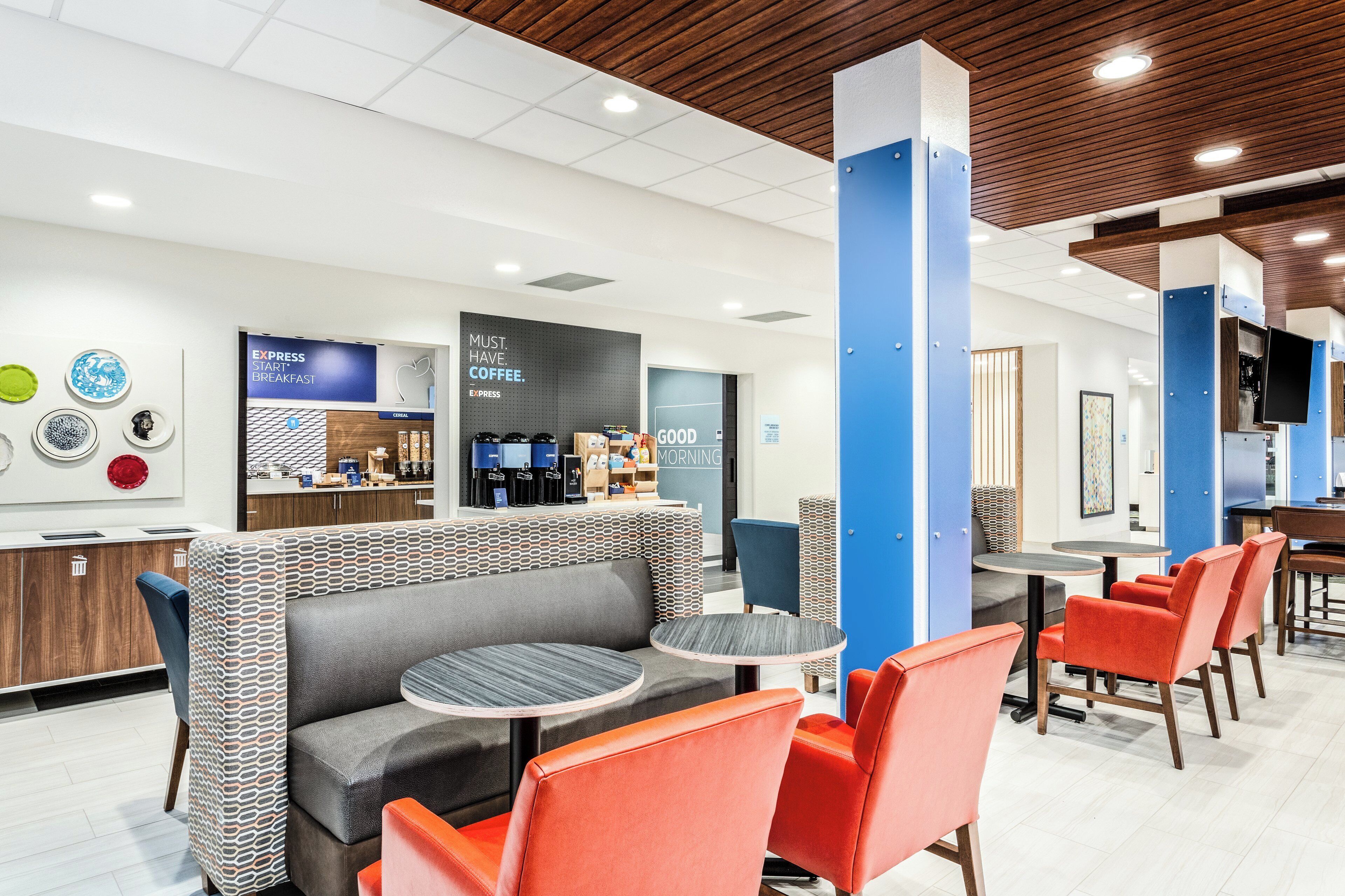 A modern cafe with seating, a coffee station, and a breakfast menu.