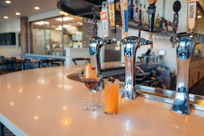 A bar area with a counter, two taps, and two drinks.