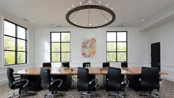 A conference room with a large table, six chairs, and a chandelier.