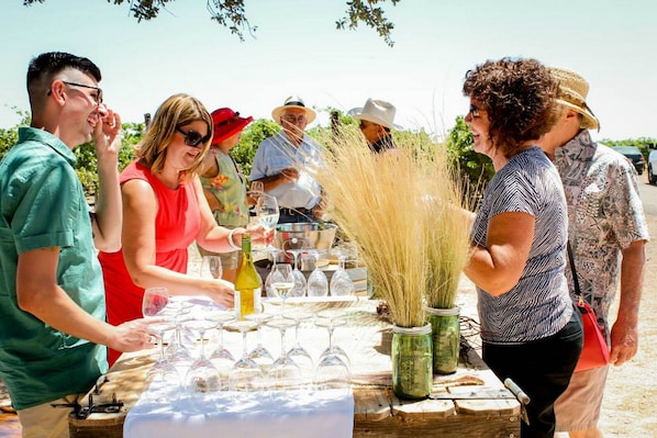 A group of people at an outdoor event with a table set up for a meal or gathering. - Hotel Winters (Winters)