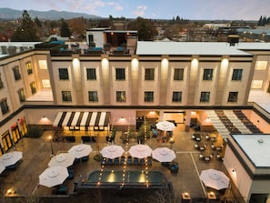 A hotel courtyard with outdoor seating, a pool, and a view of the surrounding cityscape. - Hotel Winters (Winters)