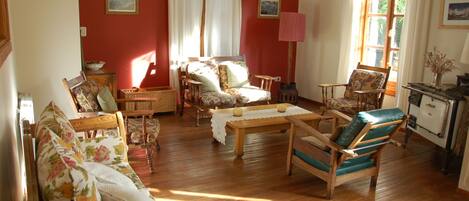 A cozy living room with wooden furniture, a dining table, and a kitchen area.