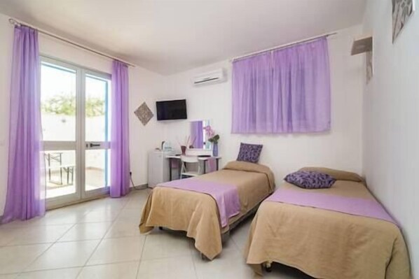 Un dormitorio con dos camas, un escritorio y un televisor.