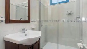 A bathroom with a shower, a toilet, a sink, and a mirror. - Signorino Resort Quadruple Studio Apartment (MARSALA)