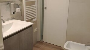 Un baño con lavabo, inodoro y perchero para toallas.