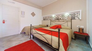 Een slaapkamer met een bed, een nachtkastje, een rood vloerkleed, een deur en een wand met een decoratief tegelpatroon.