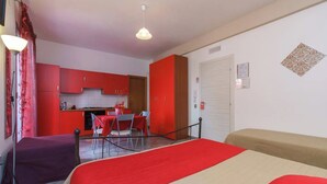 Een kamer met een bed, een eettafel en een kitchenette.