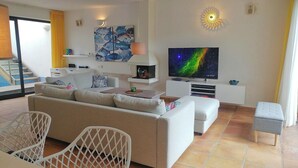 Un soggiorno moderno con divano, televisore e decorazioni alle pareti.
