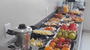 Un bufé con diversas frutas y verduras, como plátanos, naranjas y manzanas.