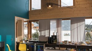 A modern kitchen with a dining area, large windows, and a view of the outside. - OVEN SUITE PREMIUM BLACK & WHITE (Les Angles)