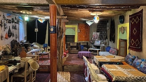 Une pièce au décor traditionnel, avec un plafond en bois, des meubles rustiques et divers objets décoratifs.