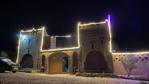 Un bâtiment doté d’une façade en pierre, de portes en arc de cercle et d  ’une entrée centrale.