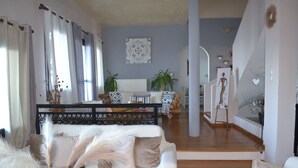 A spacious living room with a white sofa, decorative pillows, and a vase with feathers. - "Villa Erifili" Luxurious villa with spectacular view in Skiathos Island (Taxiarchis)