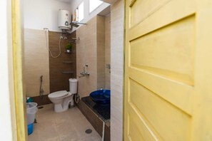 Bathroom features a toilet, sink, and shower area with a window above.