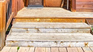 Un escalier en bois mène à une porte surmontée d’une lanterne.