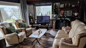 A cozy living room with leather sofas, a coffee table, and a fireplace.