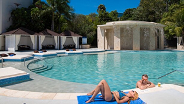Ein Swimmingpool mit Liegestühlen und einem Whirlpool.